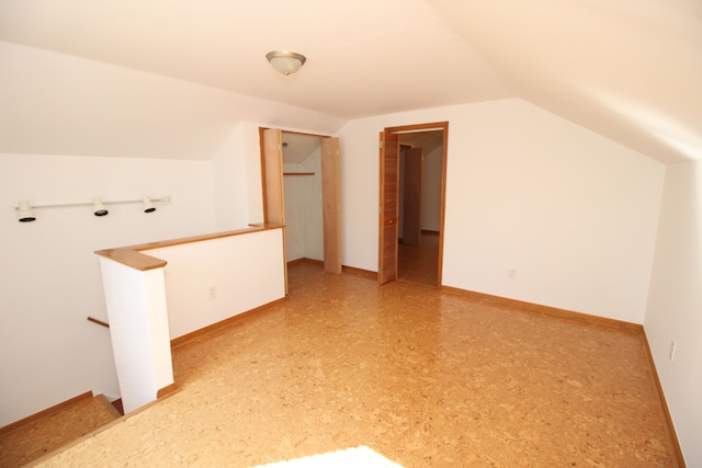 bonus room featuring lofted ceiling and baseboards