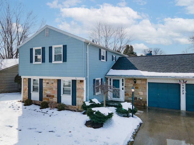 view of front of house with an attached garage, stone siding, driveway, and roof with shingles