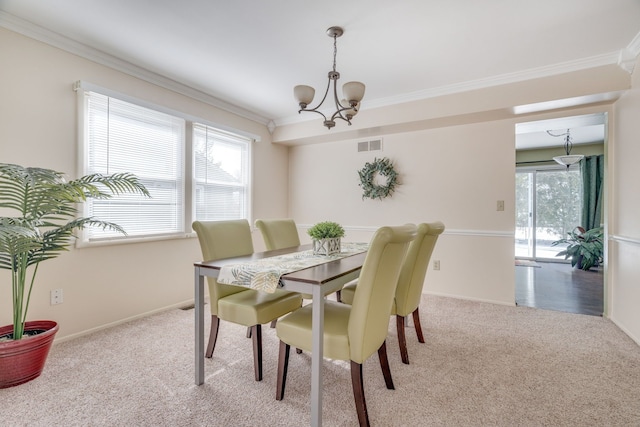 dining area featuring a notable chandelier, visible vents, baseboards, ornamental molding, and carpet