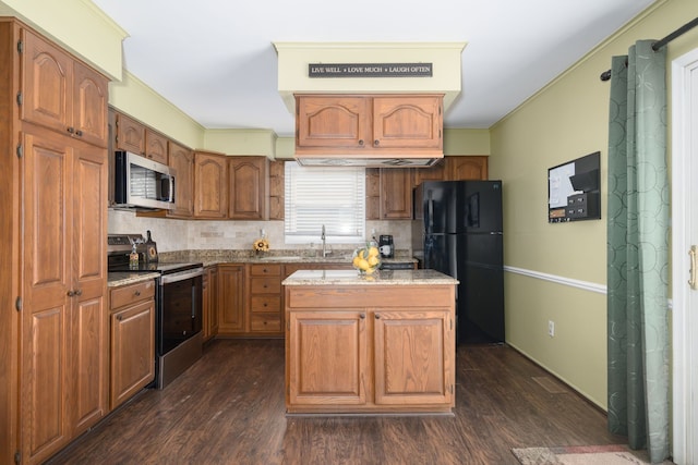 kitchen featuring a center island, stainless steel appliances, decorative backsplash, ornamental molding, and a sink