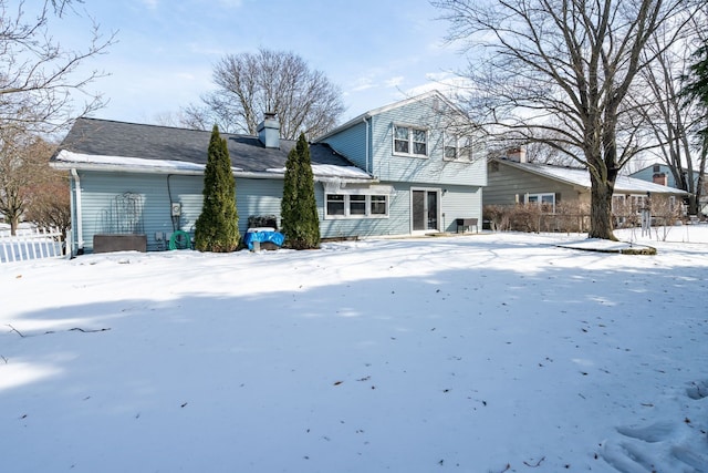 snow covered property featuring a chimney