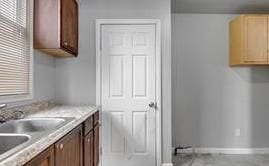 kitchen featuring light countertops, a sink, and baseboards