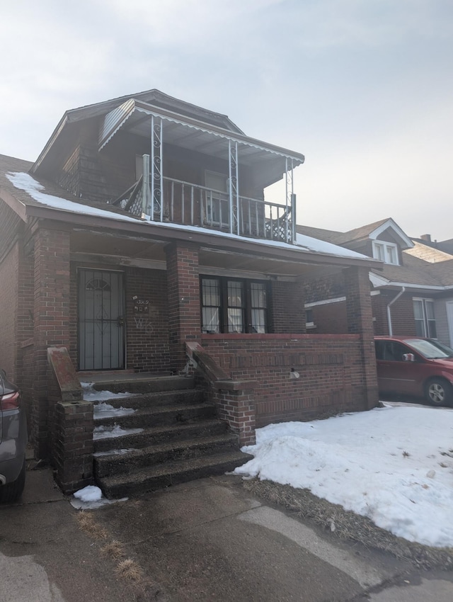 view of front of property featuring a balcony and brick siding