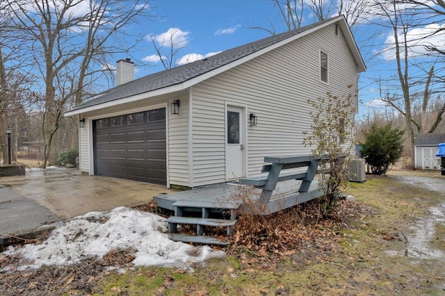 view of property exterior featuring a deck, a shingled roof, a chimney, and cooling unit