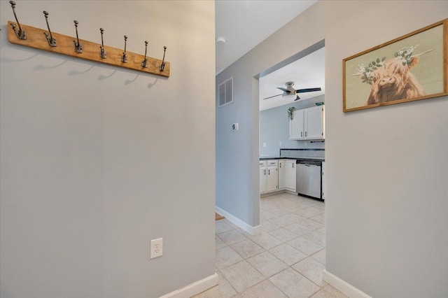 hall featuring baseboards, visible vents, and light tile patterned flooring