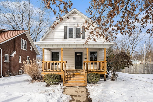 bungalow-style home with a porch and fence