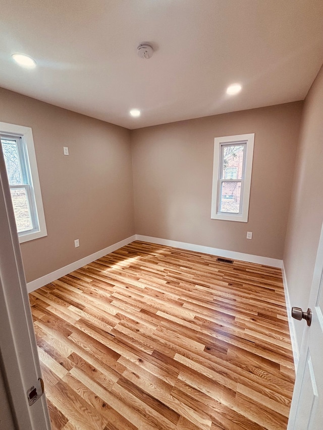 empty room with recessed lighting, a healthy amount of sunlight, and light wood-style flooring