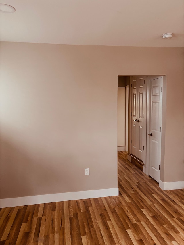 unfurnished room with baseboards and wood finished floors