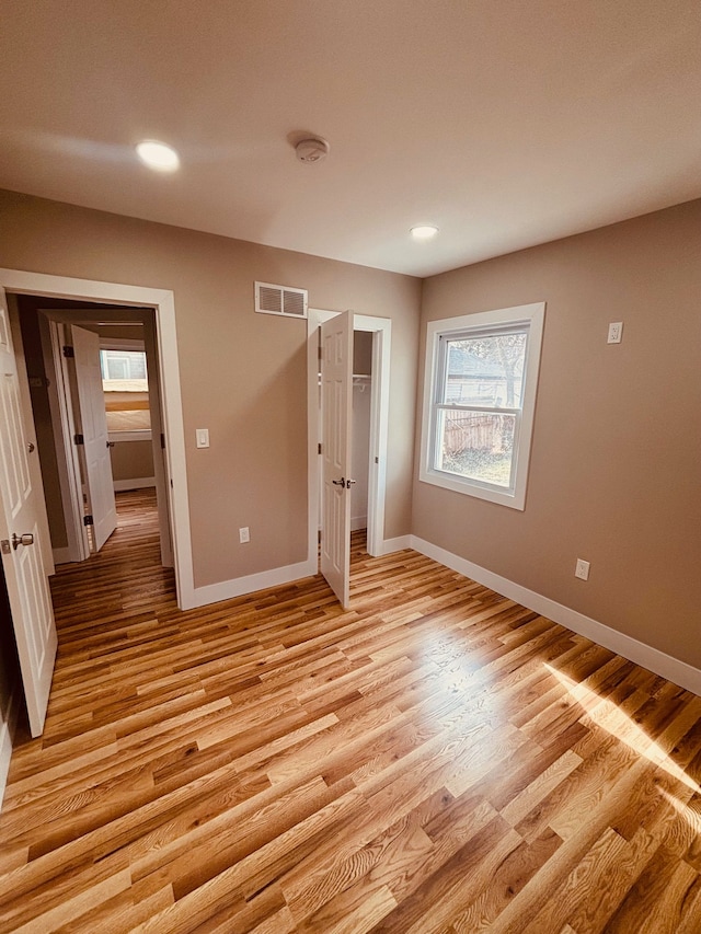 unfurnished bedroom featuring light wood-type flooring, baseboards, visible vents, and recessed lighting