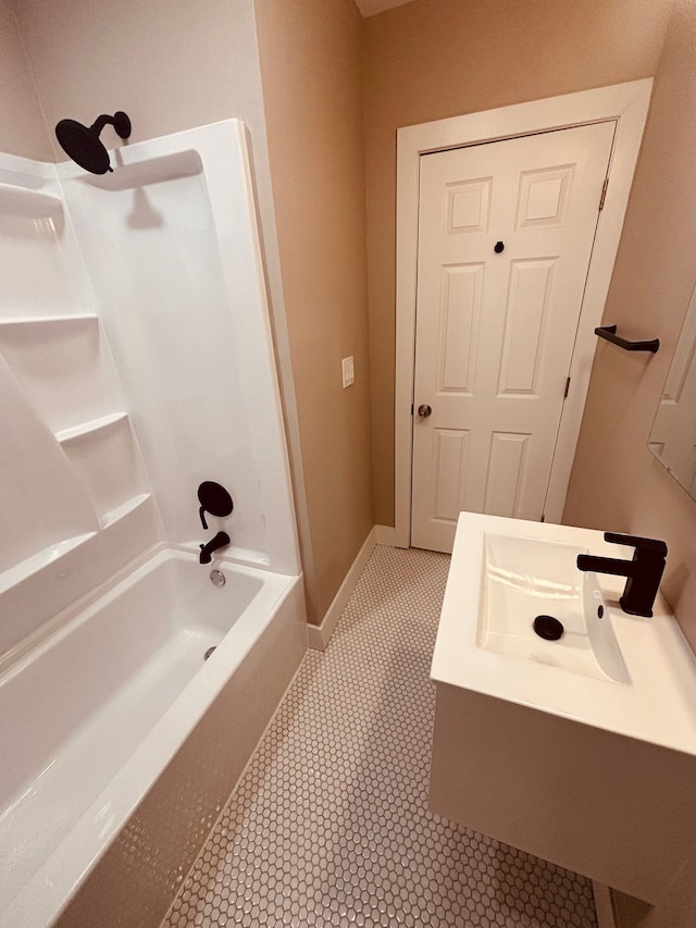 bathroom with baseboards, shower / washtub combination, and a sink