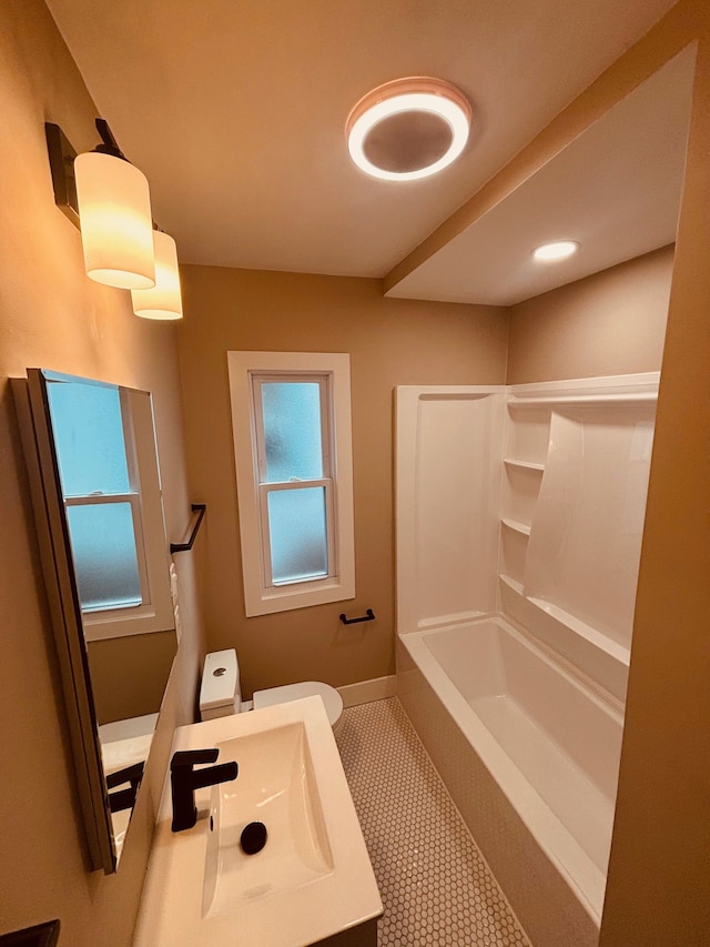 full bath featuring tile patterned flooring, toilet, vanity, baseboards, and shower / bathing tub combination