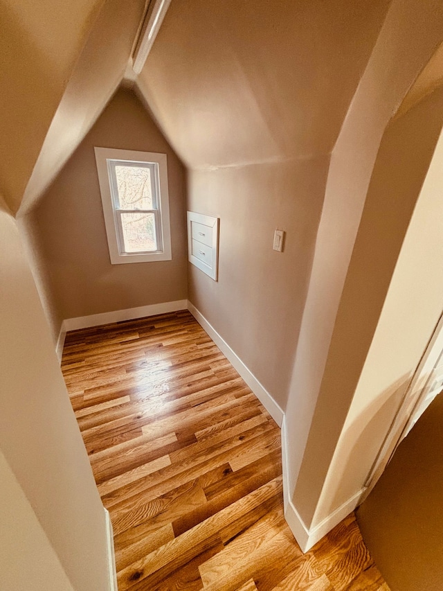 bonus room with baseboards, vaulted ceiling, and wood finished floors