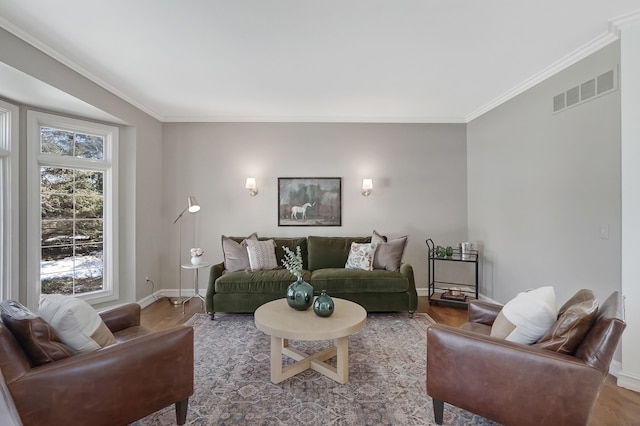 living room featuring visible vents, crown molding, baseboards, and wood finished floors