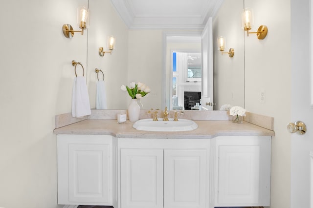 bathroom featuring ornamental molding, a fireplace, and vanity