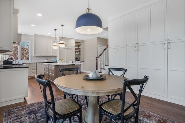 dining room featuring recessed lighting, dark wood finished floors, and stairway