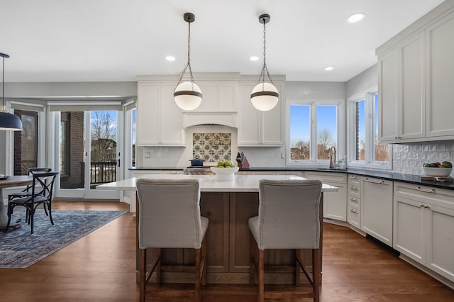 kitchen featuring a wealth of natural light, a breakfast bar area, dark wood finished floors, and a sink