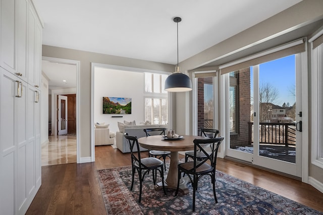 dining area featuring dark wood-style flooring and baseboards