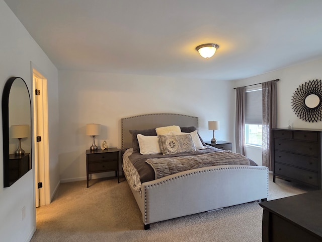 bedroom with light carpet and baseboards