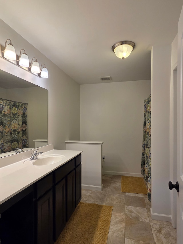 full bath featuring visible vents, curtained shower, vanity, and baseboards