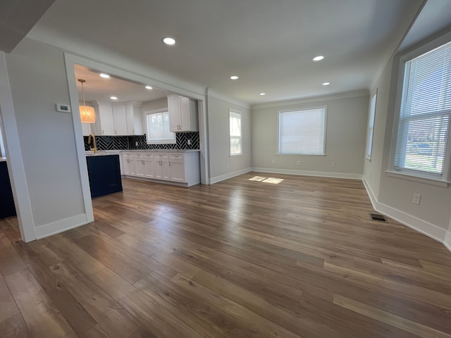 unfurnished living room with dark wood-style floors, recessed lighting, visible vents, and baseboards