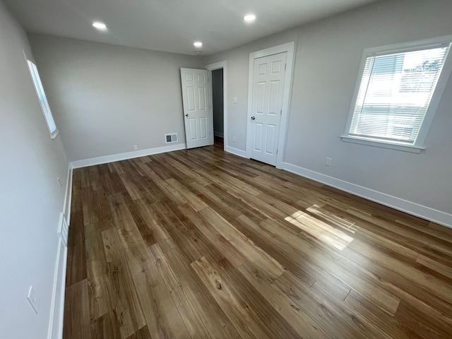 unfurnished bedroom with recessed lighting, wood finished floors, visible vents, and baseboards