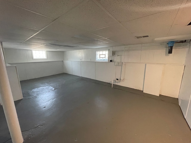 basement featuring a paneled ceiling and visible vents