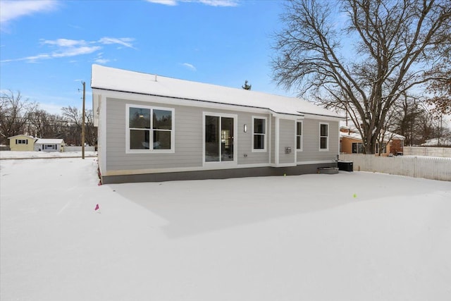 snow covered rear of property with central air condition unit