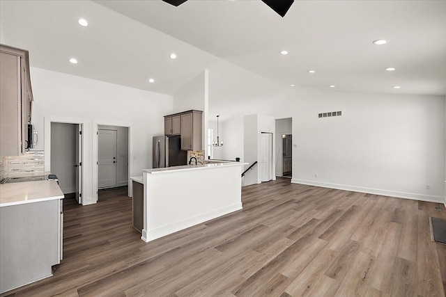 kitchen with gray cabinetry, stainless steel appliances, dark wood-type flooring, visible vents, and open floor plan