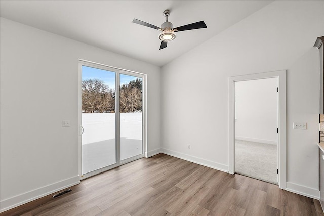 spare room with light wood finished floors, visible vents, baseboards, lofted ceiling, and ceiling fan