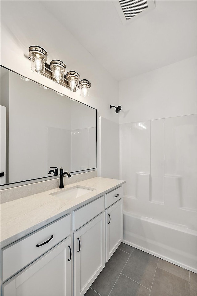 bathroom with visible vents, washtub / shower combination, vanity, and tile patterned floors