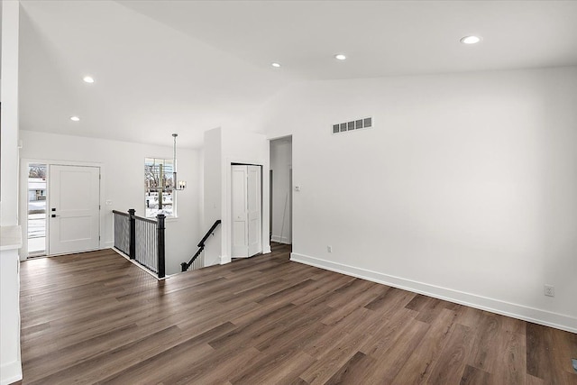 empty room with dark wood finished floors, visible vents, vaulted ceiling, and recessed lighting