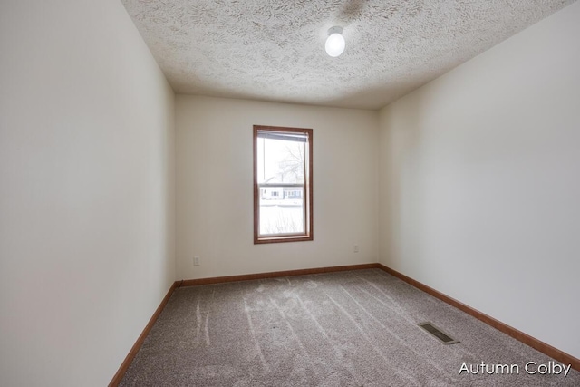 carpeted empty room featuring a textured ceiling, visible vents, and baseboards