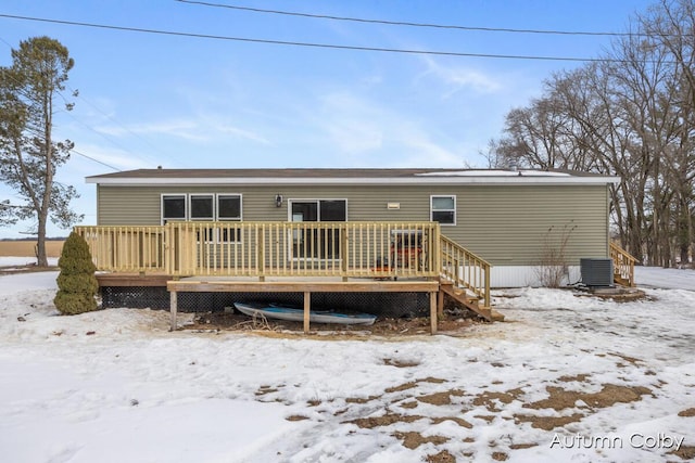 snow covered back of property featuring a wooden deck and central air condition unit