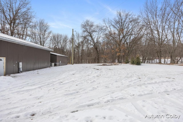 snowy yard featuring a garage