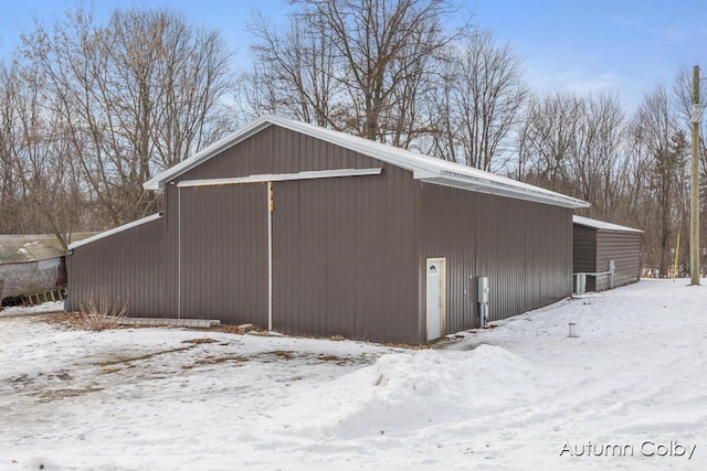 snow covered garage with a detached garage