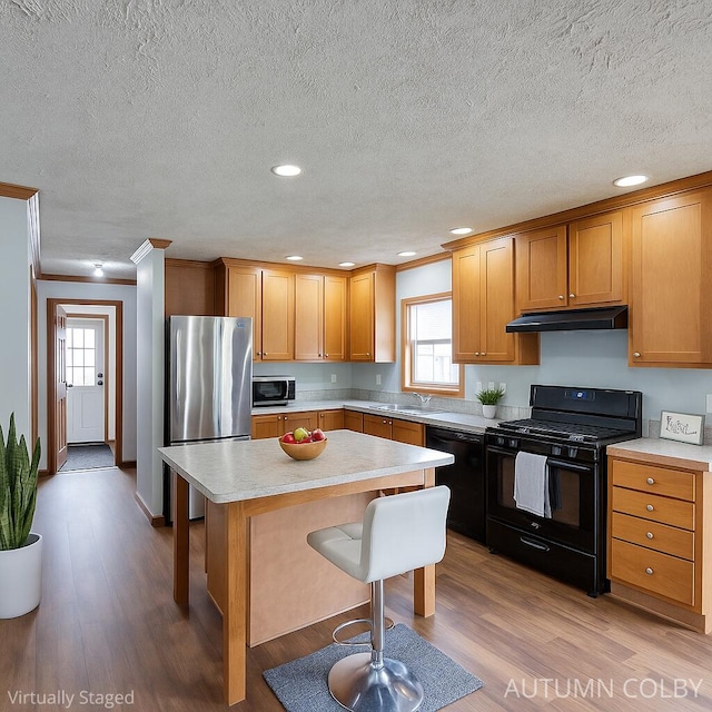 5443 Gravel Ridge Rd, Lakeview, MI 48850 - kitchen featuring black appliances, plenty of natural light, a breakfast bar area, light wood-type flooring, and crown molding