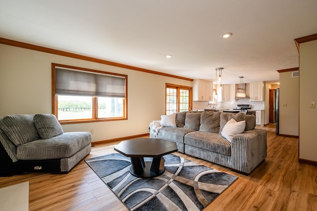 living area featuring recessed lighting, visible vents, baseboards, ornamental molding, and light wood-type flooring