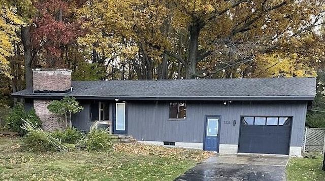 exterior space with a garage, driveway, and a chimney