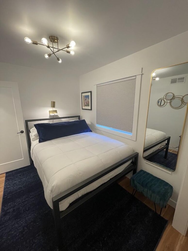 bedroom featuring visible vents and wood finished floors