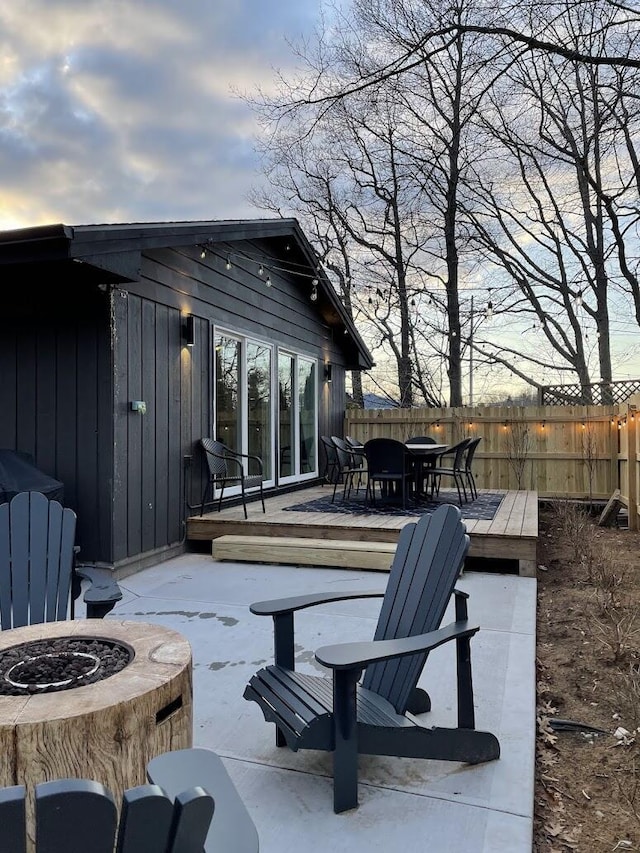 view of patio featuring an outdoor fire pit and fence