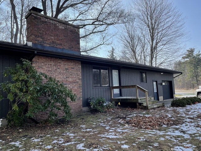 exterior space with brick siding and a chimney