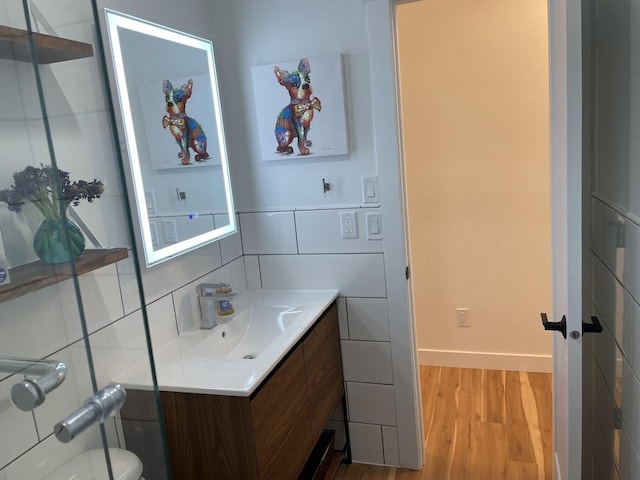 bathroom with tile walls, toilet, decorative backsplash, vanity, and wood finished floors