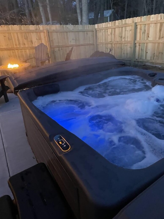 view of pool with a hot tub and fence