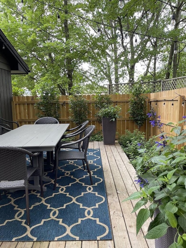 view of patio / terrace featuring outdoor dining space, a fenced backyard, and a wooden deck