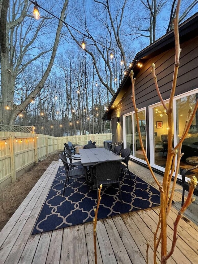 deck featuring outdoor dining space and a fenced backyard