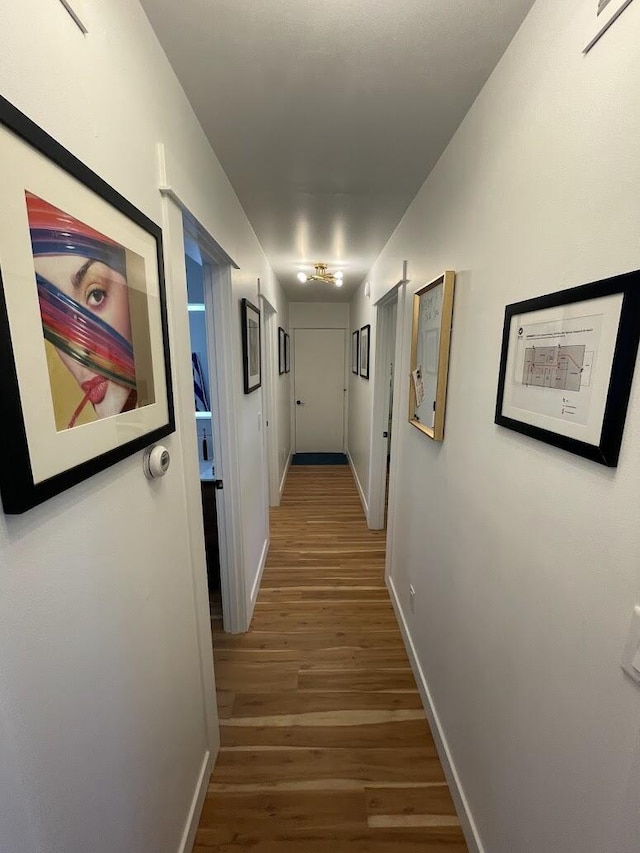 hallway featuring wood finished floors and baseboards