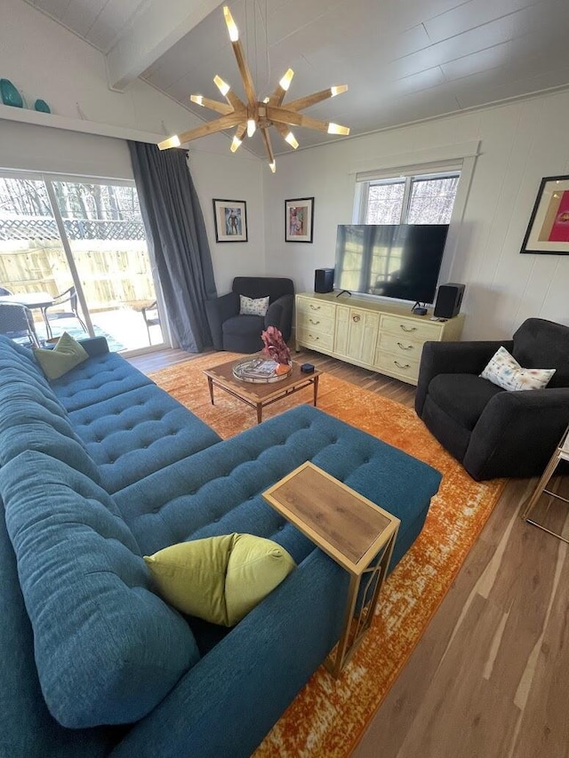 living area featuring a chandelier, wood finished floors, and vaulted ceiling with beams