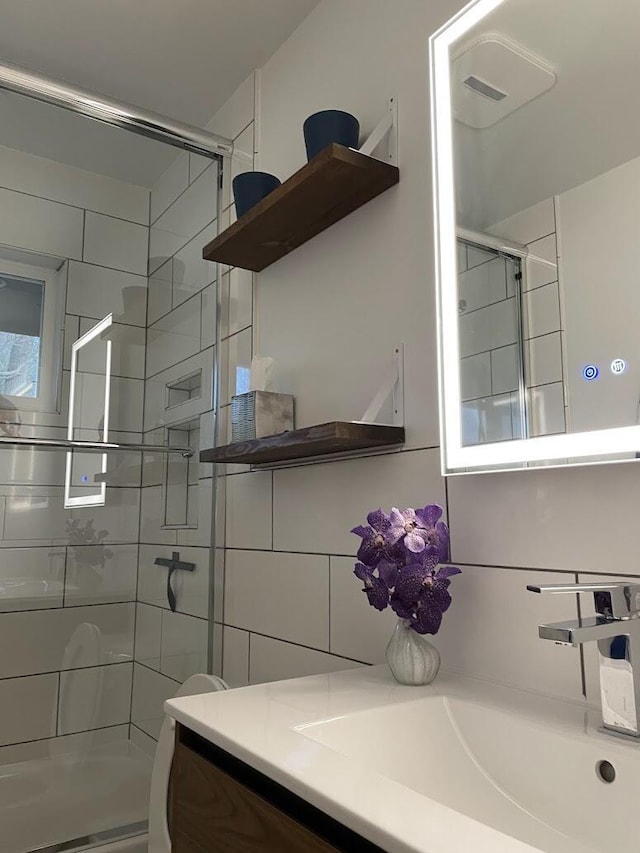 full bathroom featuring decorative backsplash, a shower stall, vanity, and tile walls