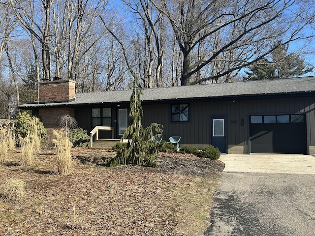 view of front of house with an attached garage, driveway, and a chimney