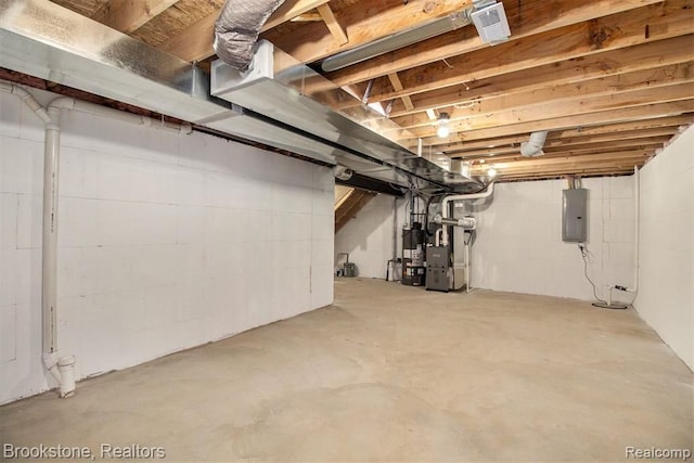 unfinished below grade area featuring electric panel, gas water heater, and heating unit